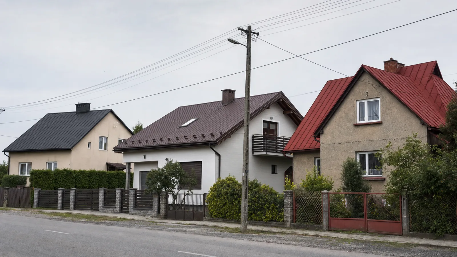 Trzy świeżo pomalowane dachy w grafitowym, brązowym i czerwonym kolorze w popołudniowym świetle